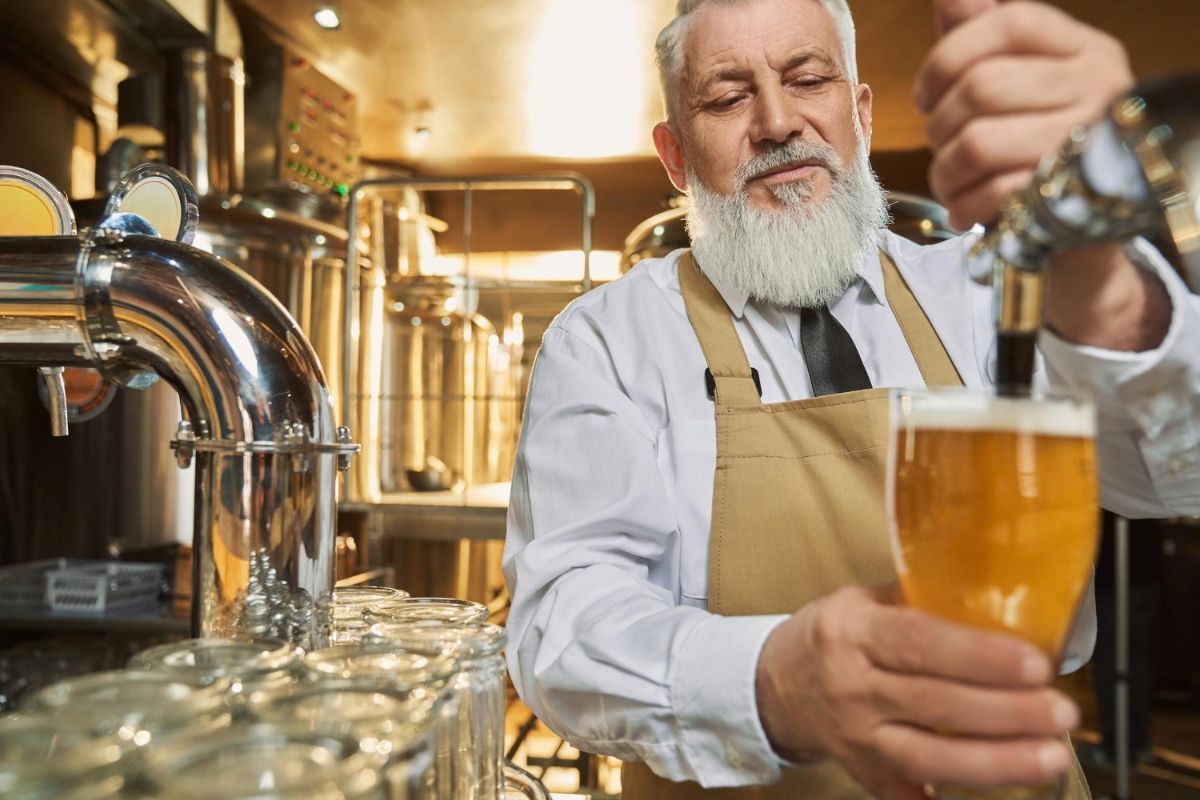 Maestro cervecero sirve una cerveza desde un cañero