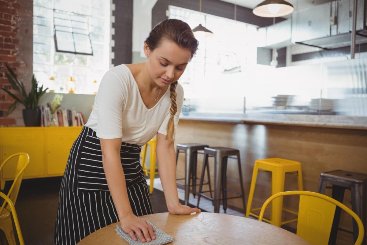 Runner limpia una mesa tras finalizar el servicio en un restaurante
