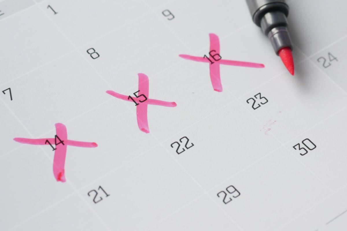 Un calendario con varias fechas señaladas en rotulador rosa