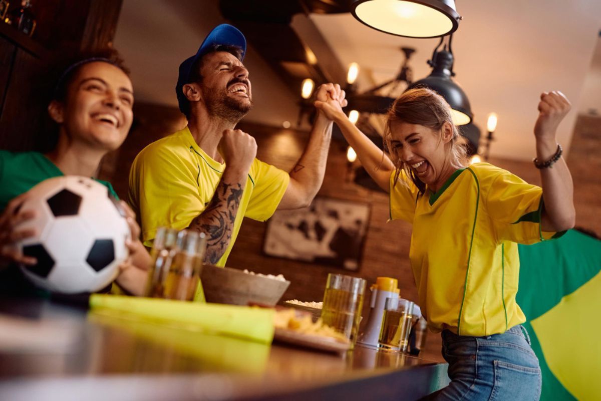 varios clientes celebran un gol de su equipo en un bar